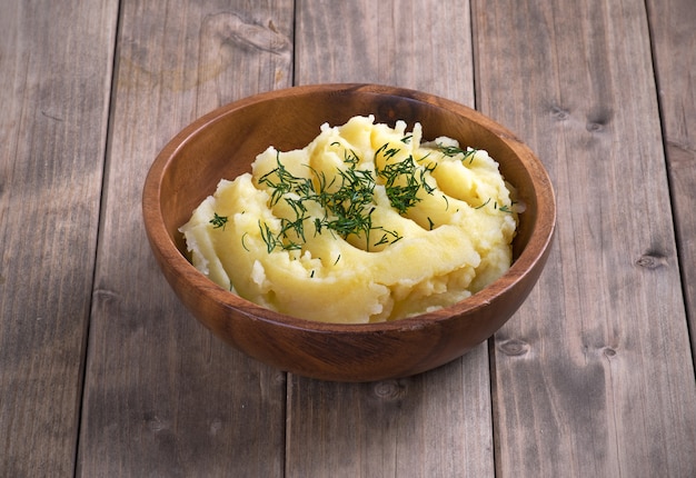 Purê de batata em um prato de madeira sobre a mesa