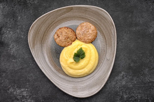 Purê de batatas com costeletas de vapor e salsa