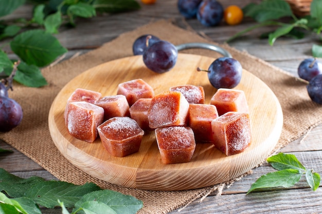 Purê de frutas congeladas em cubos de gelo em cima da mesa. Ameixa congelada, ameixa cereja. Armazenamento de alimentos