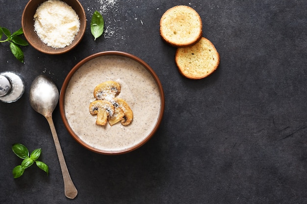 Purê de sopa com cogumelos e queijo em um fundo de concreto.