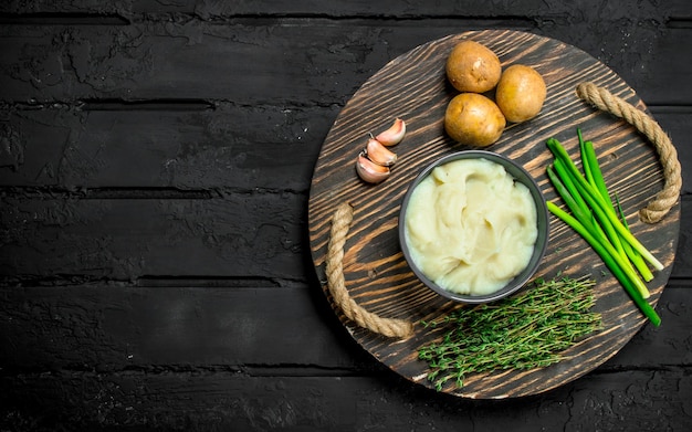 Foto puré de patatas en un bol con hierbas y ajo