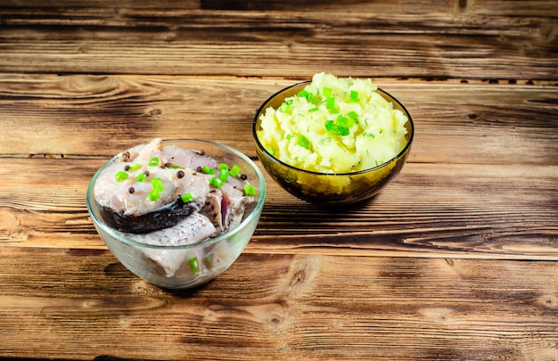 Puré de patatas y carpa marinada sobre mesa de madera