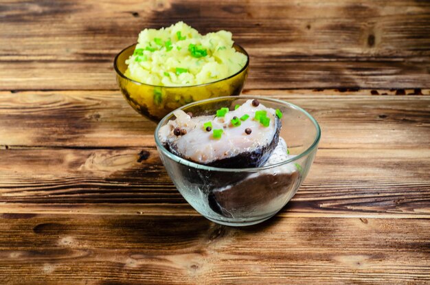 Puré de patatas y carpa marinada sobre mesa de madera