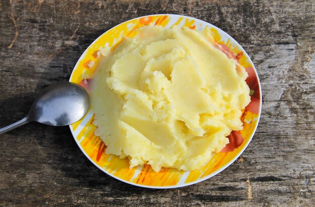 Puré de patatas en un plato sobre la mesa de madera rústica