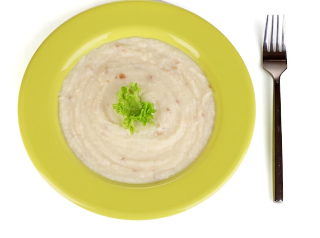 Puré de patatas en plato verde aislado en blanco