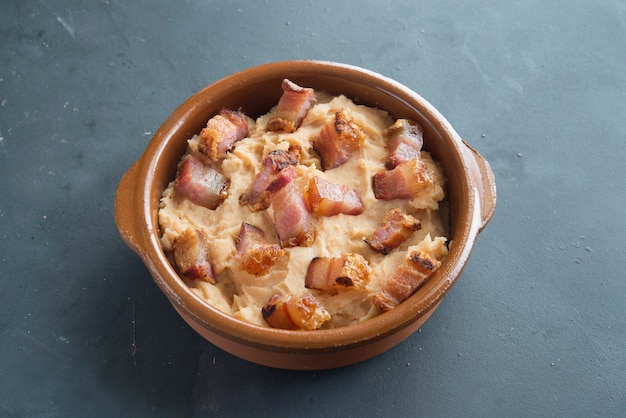 Puré de patatas con rodaja de tocino