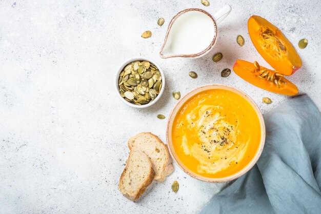 Puré de sopa de calabaza con crema en un cuenco blanco