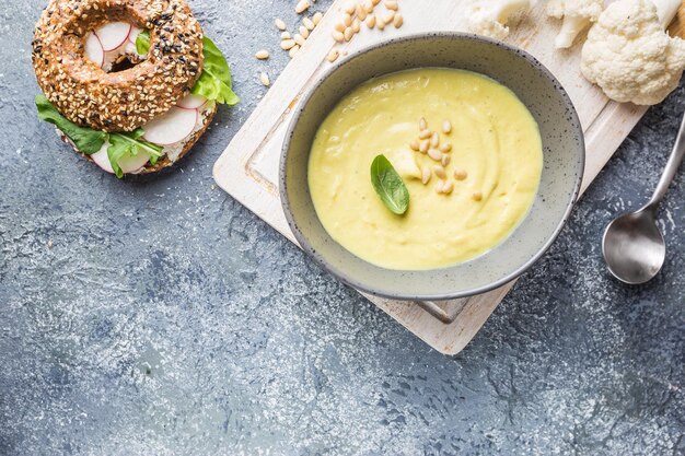 Puré de sopa de coliflor sobre un fondo de piedra, vista superior. Concepto de comida sana vegetariana