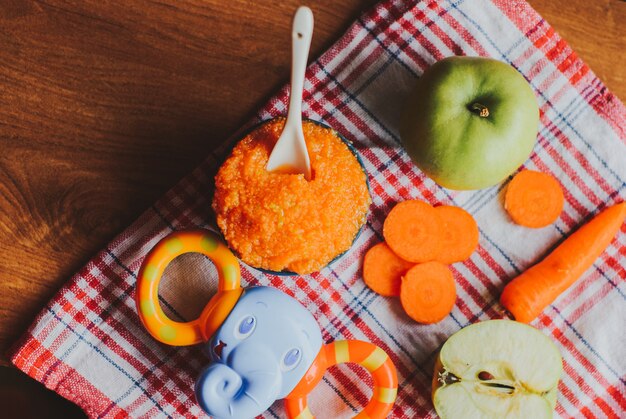 Puré de zanahoria de comida para bebés con manzanas verdes en un tazón de cerámica