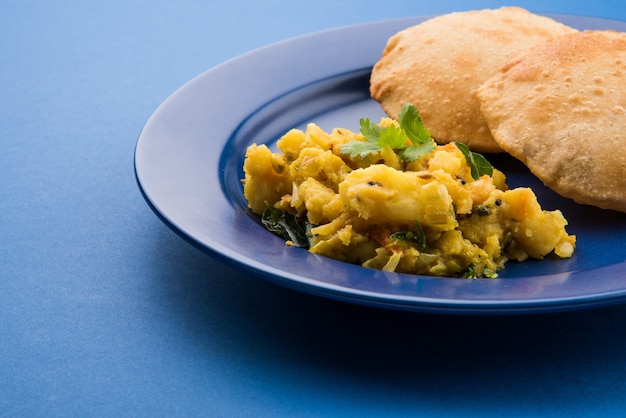 Puri Bhaji - Indische halbtrockene Kartoffel Würziges Rezept, auch bekannt als Batata oder Aloo ki Sabji, serviert mit gebratenem Poori. Selektiver Fokus