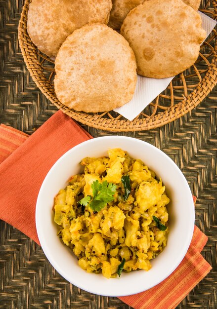 Puri Bhaji - Receta picante india de papa semiseca también conocida como Batata o Aloo ki Sabji, servida con Poori frito. Enfoque selectivo