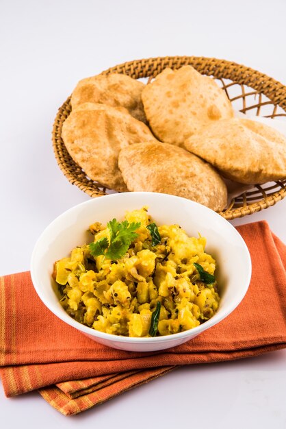 Puri Bhaji - Receta picante india de papa semiseca también conocida como Batata o Aloo ki Sabji, servida con Poori frito. Enfoque selectivo