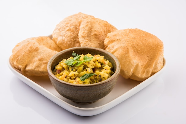 Puri Bhaji - Receta picante india de papa semiseca también conocida como Batata o Aloo ki Sabji, servida con Poori frito. Enfoque selectivo