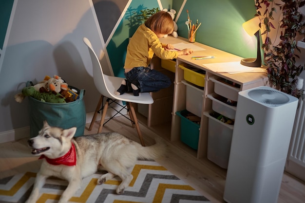 Purificador de aire en la habitación de los niños con un niño alérgico y un perro