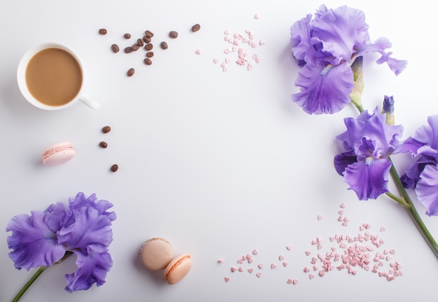 Purpurrote irisblumen und ein tasse kaffee auf weiß