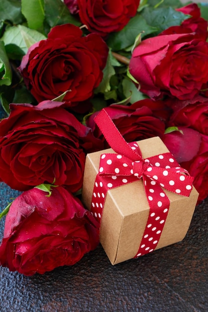 Purpurroter Rosenblumenstrauß mit Geschenkbox Valentinstaghintergrund