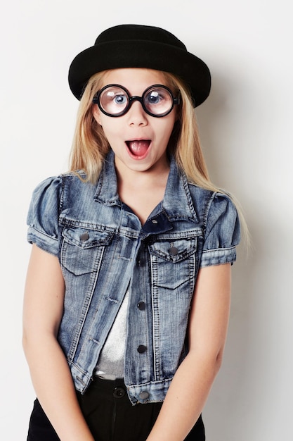 Puxando um rosto Retrato de uma jovem usando grandes óculos redondos posando no estúdio