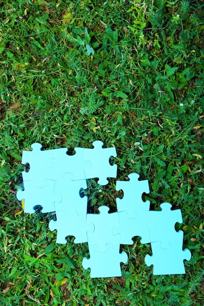 Puzzleteile auf grünem Gras Hintergrund Grünflächenkonzept