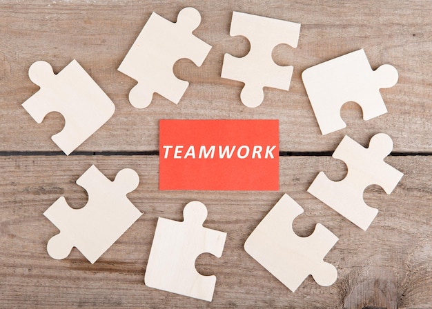 Foto puzzleteile mit wort teamwork auf holzhintergrund