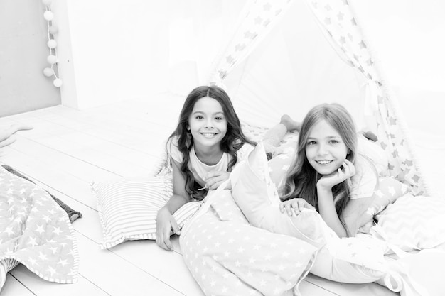 Pyjamaparty für Kinder Geschwister beste Freundinnen Schwestern oder beste Freundinnen verbringen Zeit miteinander im Schlafzimmer Mädchen haben gemeinsam Spaß Mädchenhafte Freizeit Schwesternfreunde tauschen Klatsch aus und haben Spaß zu Hause