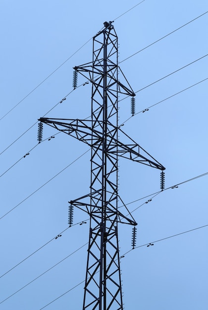 Pylon der Stromleitung vor hellblauem Hintergrund