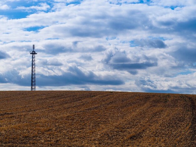 Pylon de electricidad en el campo contra el cielo