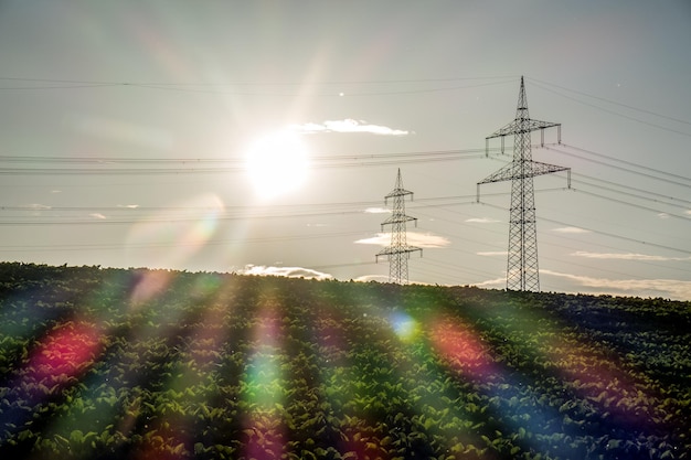 Foto pylon de electricidad en el campo contra el sol brillante