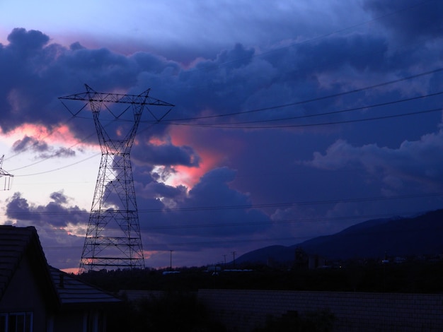 Pylon de electricidad en la montaña contra el cielo nublado