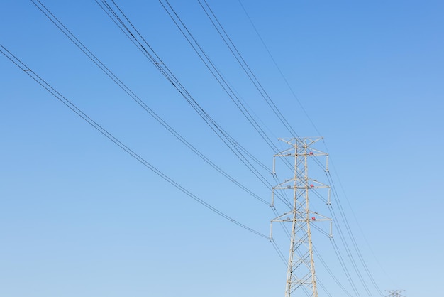 Pylon und Hochspannungsleitung über dem blauen Himmel