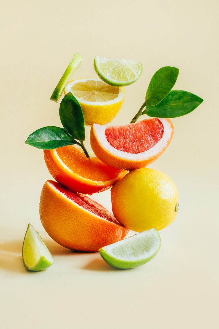 Foto pyramide von zitrusfrüchten grapefruit, orange, zitrone, limette auf gelb