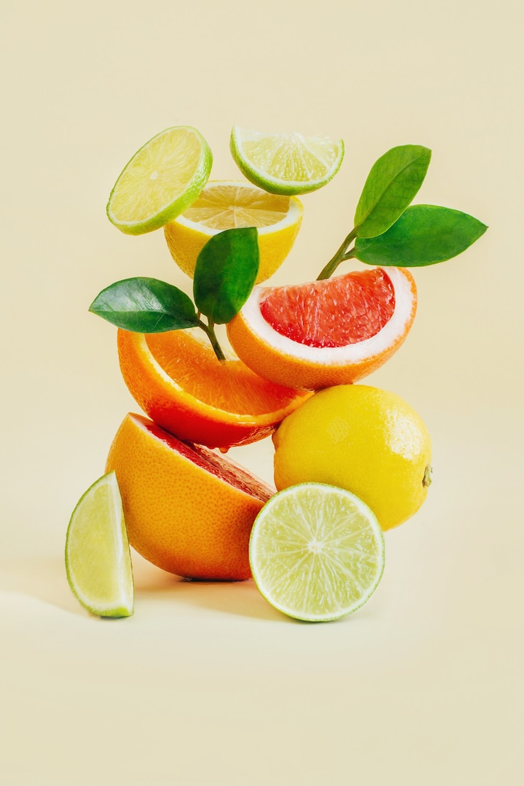 Foto pyramide von zitrusfrüchten grapefruit, orange, zitrone, limette auf gelb
