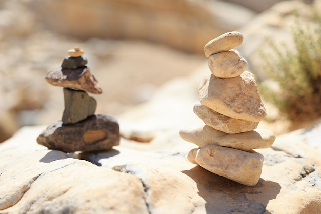 Foto pyramidensteine balancieren auf dem sandfelsen, das objekt ist scharfgestellt, der hintergrund ist von hoher qualität verschwommen