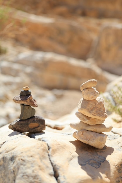 Foto pyramidensteine balancieren auf dem sandfelsen, das objekt ist scharfgestellt, der hintergrund ist von hoher qualität verschwommen