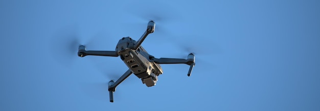 Quadcopter com câmera fotográfica e vídeo pendurada no céu.
