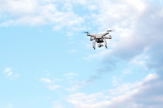 Quadcopter drone com a câmera contra o céu azul