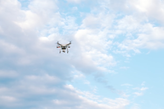 Quadcopter drone com a câmera contra o céu azul