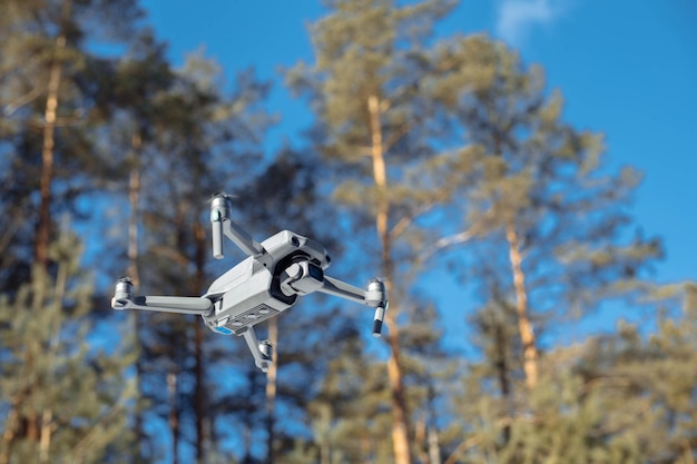 Quadcopter im Wald gegen den blauen Himmel