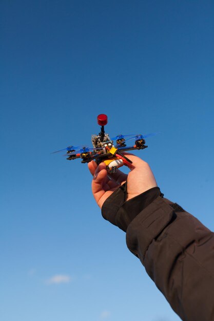 Foto quadcopter en mano fondo de cielo