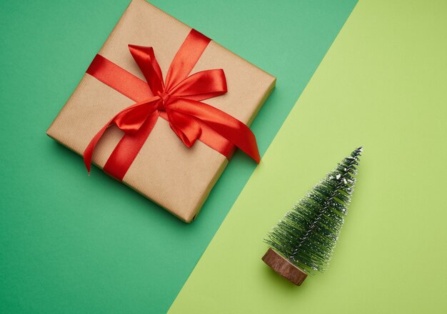 Quadratische Schachtel mit rotem Seidenband und dekorativem Weihnachtsbaum
