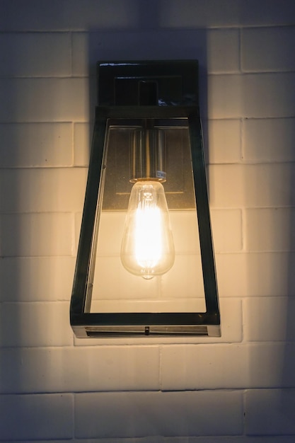 Quadratische Stahllampe wolframwarmes Licht an der weißen Ziegelwand
