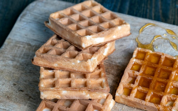 Quadratische süße weiche Waffeln in Bienenhonig