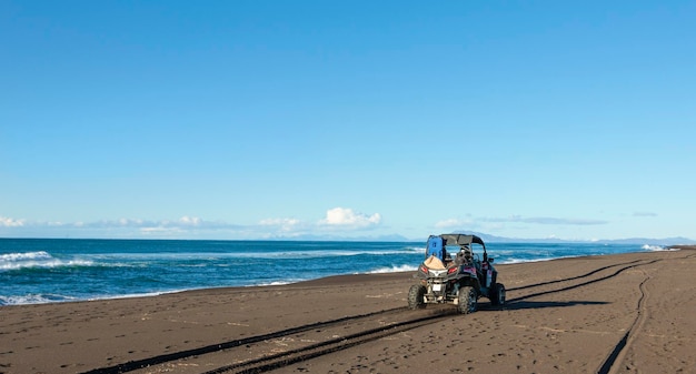 Quadriciclo na areia perto do oceano pacífico