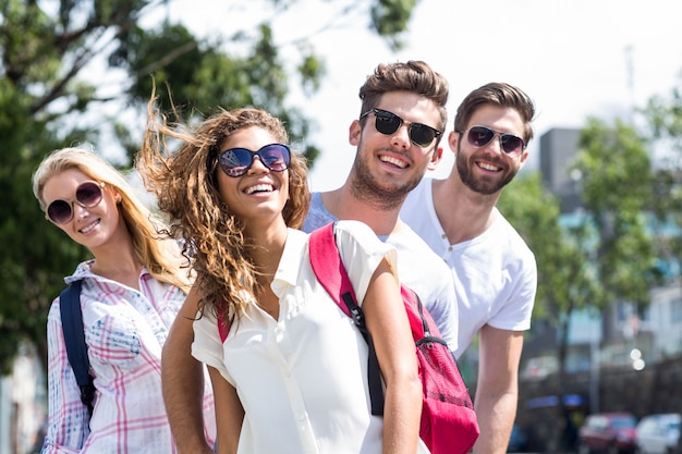 Foto quadril amigos andando na rua e sorrindo para a câmera