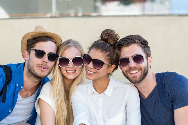 Quadril amigos posando para uma foto enquanto está sentado na calçada