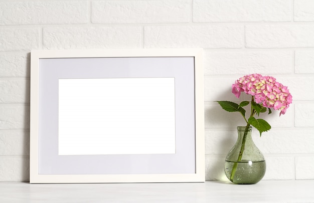 Quadro branco vazio e hortênsia flor em vaso