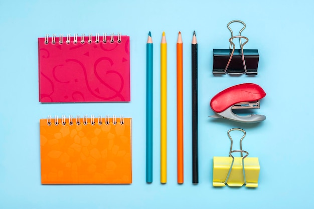 Quadro da escola e material de escritório isolado em fundo azul de volta ao conceito de educação escolar