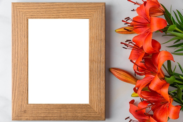 Foto quadro de foto em branco com flores de lírio laranja em fundo branco maquete de casamento plano ou mães