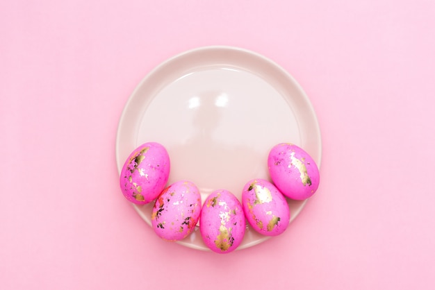 Quadro de ovos decorados dourados da Páscoa no fundo do rosa pastel.