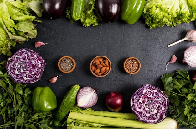 Quadro de vegetais orgânicos para cozinhar refeições saudáveis vegetais roxos e verdes sementes de nozes em tigelas de madeira vista superior fundo preto