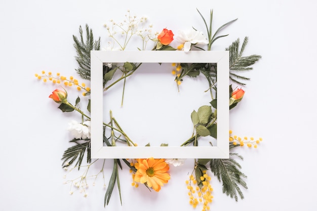 Quadro em branco em diferentes flores na mesa